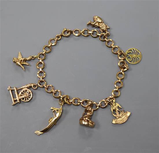 A yellow metal charm bracelet, hung with seven assorted charms including 9ct gold, gross 15.4 grams.
